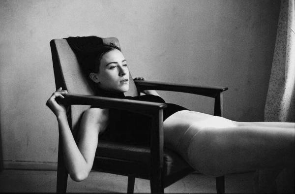 girl lying back in chair black and white